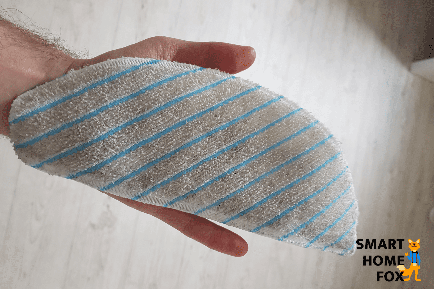 Dreckiger Wischmopp eines Saug-Wisch-Roboters wird in den Händen gehalten